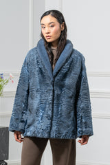 A blue Swakara jacket with a long-hair fur shawl collar, featuring a wavy, natural-pattern texture and a button closure at the center front.