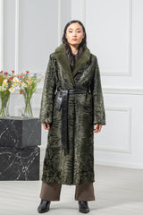 A dark olive Swakara long coat featuring a broad, matching long-hair fur collar and a black leather waist belt tied at the center.