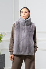Sapphire mink fur vest with a tall collar and a partial front zipper, worn over a brown sweatshirt.