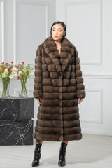 Brown Russian sable coat with a thick shawl collar and long sleeves. Features a bodice of rectangular panels and a horizontally banded skirt.