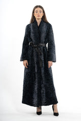 Long deep blue Swakara coat featuring a textured, rippled pelt pattern, a wide collar, and a smooth black leather waist tie.