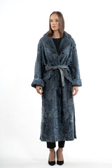 Long blue Swakara skin coat with a smooth fur collar, wide cuffs, and a matching leather waist belt tied in front.