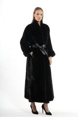 Full-length Blackglama mink coat with a stand collar, wide sleeves with turn-up cuffs, and a black leather waist belt, worn over black trousers.