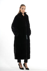 A long black Blackglama mink coat with a stand-up collar, front pockets, and a subtle V chevron pattern integrated into the fur panels.