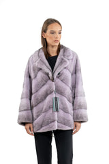 Lilac mink fur jacket with a notched collar, featuring a V-chevron pattern on the body and horizontal panels on the sleeves.