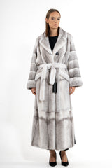 Silverblue cross mink fur coat with a wide collar, waist tie, and horizontal banded panel construction, worn over a black base.