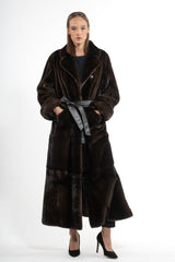 Mahogany mink fur coat with a wide collar and a black leather waist tie. The calf-length coat features vertical fur panels and side pockets.