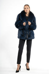 A short Blue Frost Fox fur jacket with a large shawl collar and vertical construction, worn open over black trousers.