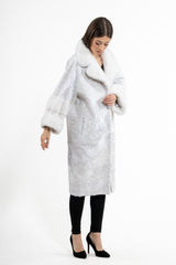 White Swakara skin jacket with a long fit. It features a large white mink fur collar and cuffs, with diagonal panel construction on the body.