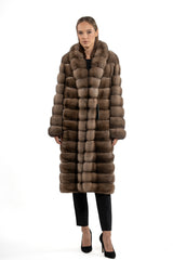 Knee-length Russian sable jacket in brown with a block-patterned construction and a wide, plush collar, worn over a dark outfit.
