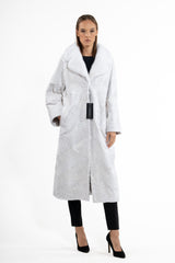 Long white Swakara coat with a contrasting long-hair fur collar, featuring diagonal chevron piecing and side pockets.
