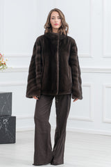 Brown mink fur jacket with a high stand collar, wide sleeves, and a subtle V-chevron pattern on the sleeves, featuring an adjustable hem drawstring.
