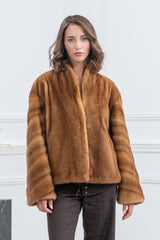 Gold mink fur jacket with a short, boxy silhouette, standing collar, and wide sleeves featuring diagonal panel construction.