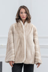 A short, cinnamon mink fur jacket for women featuring a V-chevron pattern on the chest, a standing collar, and wide sleeves.