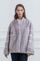 Silver blue mink fur jacket with a V chevron pattern on the body and horizontally banded long sleeves. Features a simple collarless neckline.