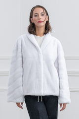Front view of a white mink fur short jacket with a shawl collar, featuring V-chevron patterns on the sleeves and a drawstring hem with silver ends.