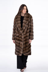 Russian sable jacket featuring a V-chevron pattern, large lapel collar, and knee-length straight silhouette over black trousers.