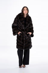 Carbonio silvery Russian sable jacket featuring a V chevron fur pattern, wide collar, and long sleeves, worn over a black top and trousers.