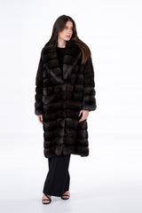 Russian sable coat in a deep carbonio silvery brown, featuring a horizontal-paneled design and a wide, plush collar on a woman.