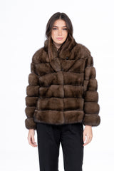 Short jacket in brown Russian sable with a horizontal panel construction, a rounded collar, and long sleeves.