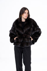 Dark brown Russian sable short jacket featuring a V-chevron pattern, wide lapel collar, and side pockets, worn by a model against white.
