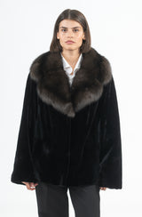 Short black mink jacket featuring a wide, plush sable fur collar, straight-cut silhouette, and hidden front closures.