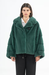 Short emerald green mink jacket with an English collar and sleeves featuring horizontal banded fur panels, secured by a single prominent button.