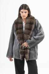 Grey mink short jacket with a wide dark brown sable collar, front hook closure, and straight silhouette.