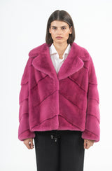 Short pink mink jacket with a V-chevron pattern, wide English collar, and a drawstring hem.