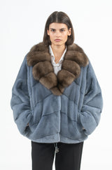 Short blue mink jacket featuring a wide brown sable collar and a V-chevron pattern where the fur panels point downward toward the center.