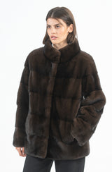 Dark brown mink short jacket with a high collar, featuring horizontal fur panel construction and side pockets.