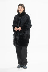 Black Swakara fur coat with mink trim at the collar and wide cuffs, featuring horizontal mink panels at the hem.